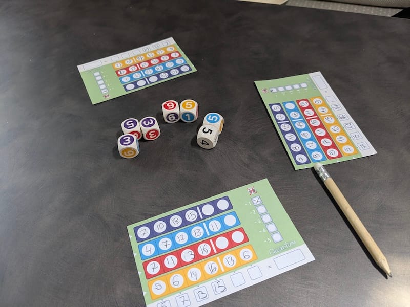 Dados de colores y bloc de notas del juego Qwantum para viajes.